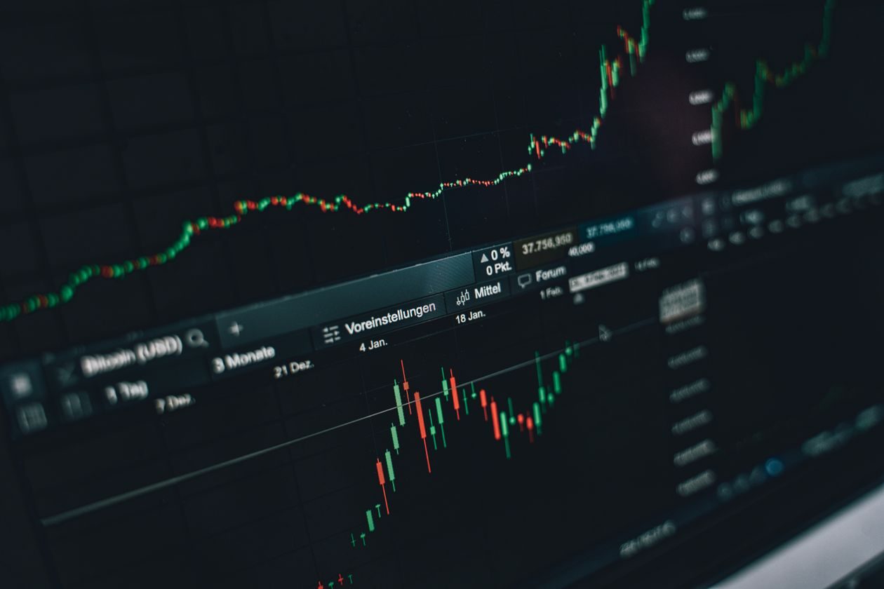 Stock market price charts with candlesticks glowing on a dark monitor screen